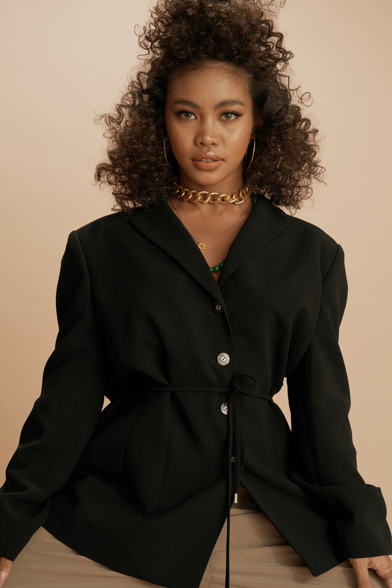 Curly-Haired Woman Wearing a Black Suit Jacket