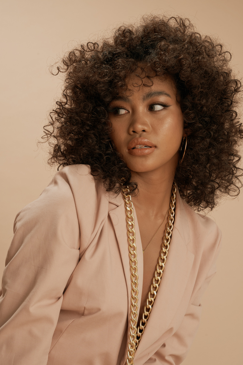 Curly-Haired Woman Wearing a Beige Suit Jacket