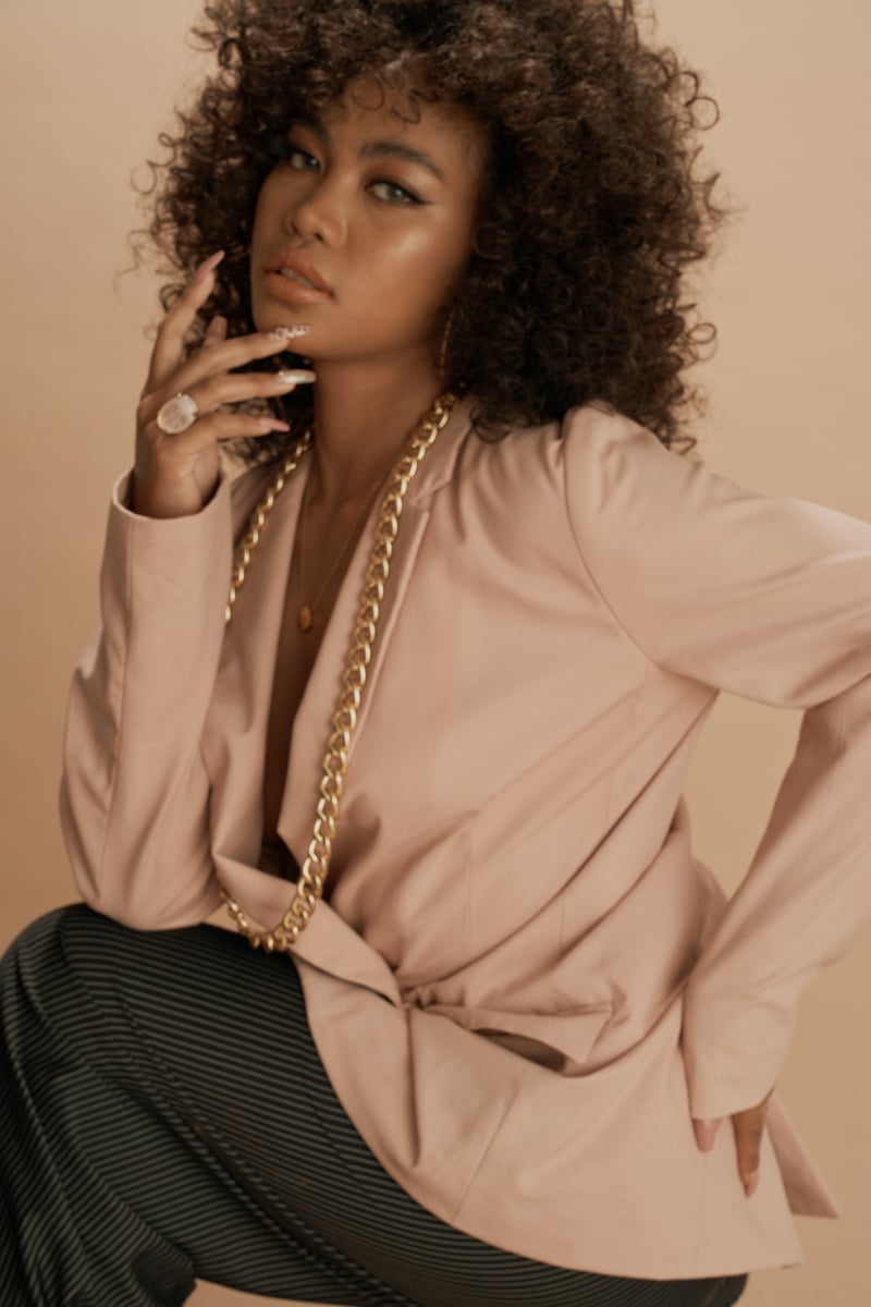 Curly-Haired Woman Wearing a Beige Suit Jacket